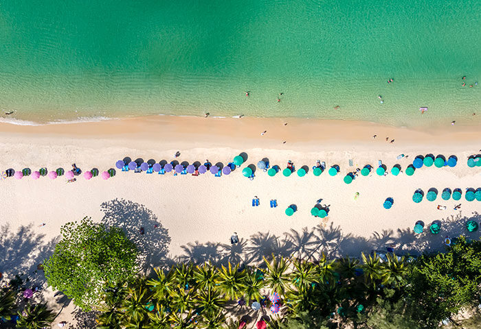 Aerial view of Outrigger Surin Beach Resort, Phuket, Thailand. Sandy beach, turquoise water, palm trees. Top gay beach hotel.