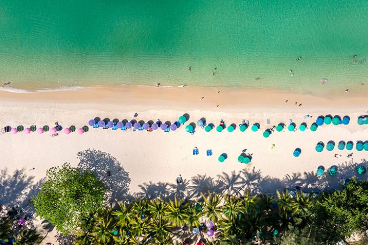 Aerial view of Outrigger Surin Beach Resort, Phuket, Thailand. Sandy beach, turquoise water, palm trees. Top gay beach hotel.