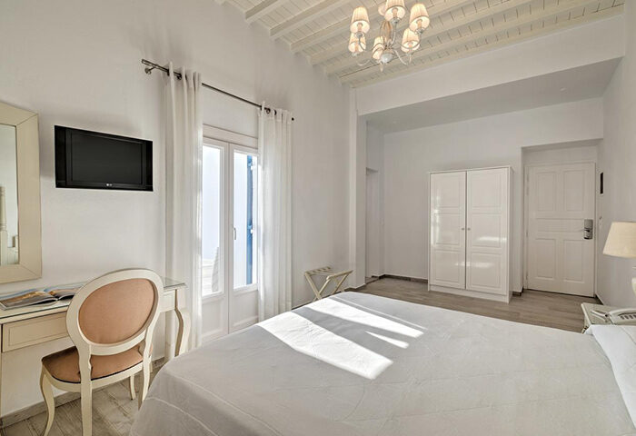 Hotel Alkyon, Mykonos Town room. White interior, double bed, desk, TV, wardrobe. Top gay choice for gay men travel advice in Mykonos.