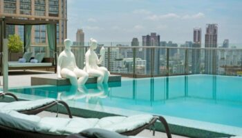 Hilton Sukhumvit Bangkok rooftop pool with city views. Top gay-friendly hotel in Bangkok, Thailand. Statues by the pool.
