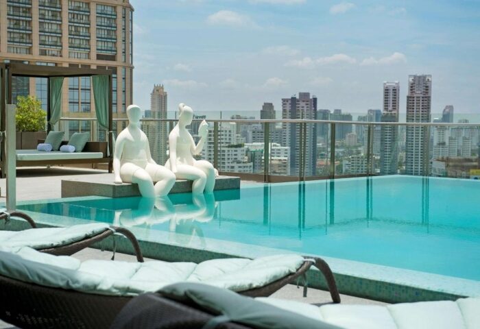 Hilton Sukhumvit Bangkok rooftop pool with city views. Top gay-friendly hotel in Bangkok, Thailand. Statues by the pool.