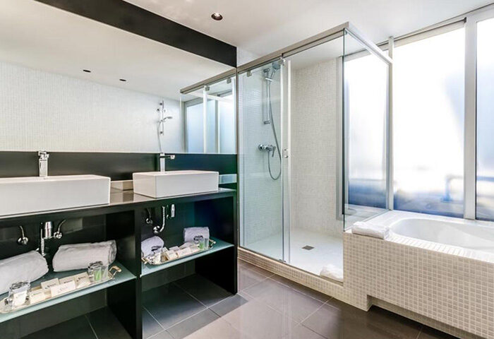 Sansi Diputacio Hotel bathroom. Modern design with double sinks, shower, and bathtub. Top gay-friendly hotel in Barcelona's Eixample area.