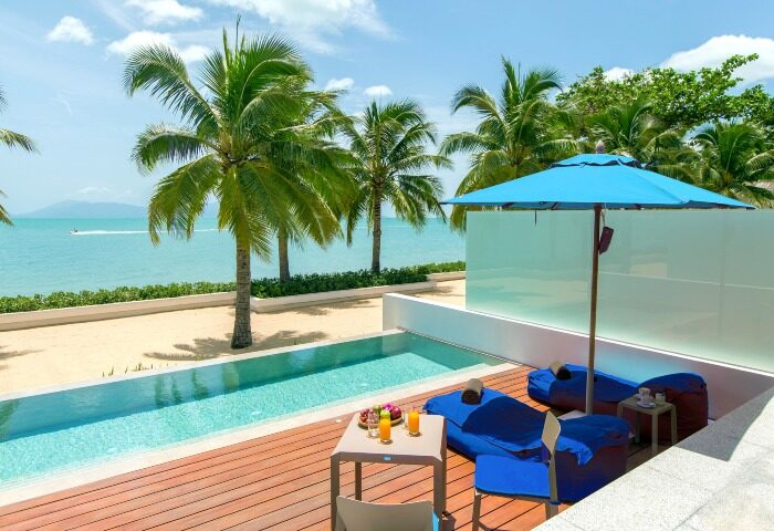 Explorar Koh Samui adults-only resort: private pool, beach view, lounge chairs, and umbrella. Top gay honeymoon destination.