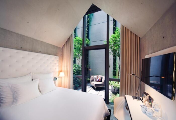 M Social Singapore hotel room with a view of the garden. Top gay honeymoon hotel. Modern design, perfect for a romantic getaway.