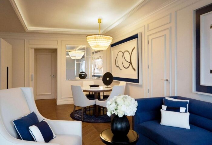 Sofitel Barcelona Skipper suite for gay honeymoon. Modern interior, blue and white decor, round table, chandelier. Top hotel in Barcelona.