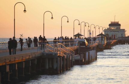 Saint Kilda Beach Hotel, Melbourne: Sunset view of the pier with people strolling. Top gay honeymoon hotels destination. Car on the pier.