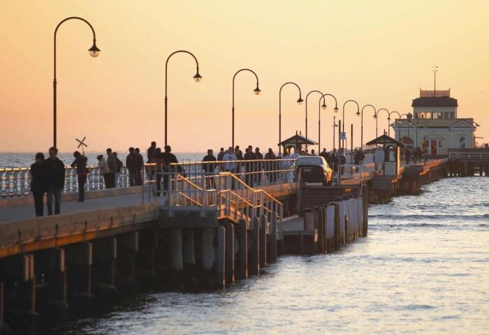 Saint Kilda Beach Hotel, Melbourne: Sunset view of the pier with people strolling. Top gay honeymoon hotels destination. Car on the pier.