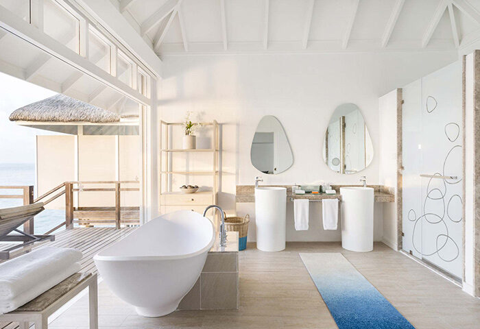 LUX* South Ari Atoll Maldives gay honeymoon. Pool villa bathroom with tub, double sinks, and ocean view. Top Maldives honeymoon destination.