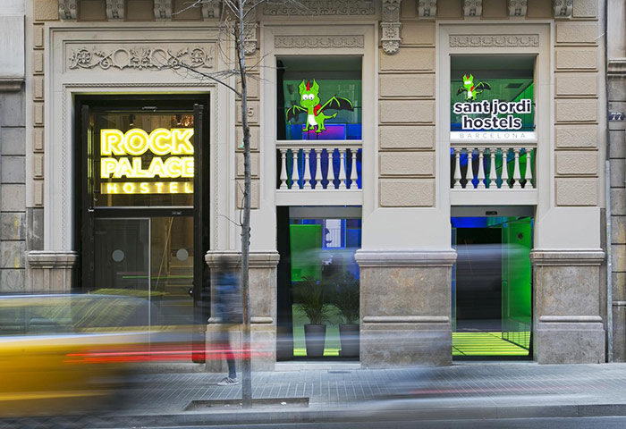 Sant Jordi Hostels Rock Palace, a top gay hostel in Barcelona near gay clubs and sauna. Facade view with Rock Palace Hostel neon sign.