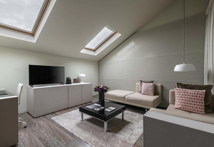 9Hotel Mercy Lisbon room. Gay hotel near Trombeta Bath, gayborhood. Modern interior, skylights, TV, seating area, sleek design. Top gay hotel.