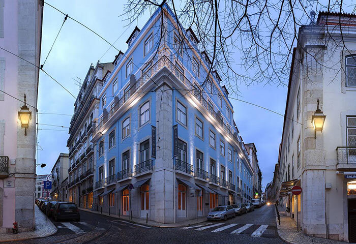 Lisboa Carmo Hotel exterior in Lisbon's city center gayborhood. Blue building on a corner with cobblestone street, a top gay hotel.