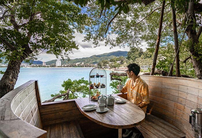 Amari Phuket gay hotel choice: Man enjoys tea with a sea view. Top Thailand destination for gay men, offering luxury and relaxation.