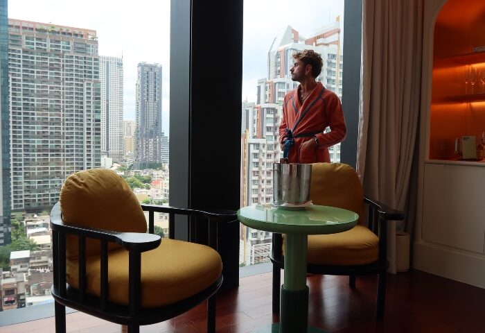 Gay traveler in robe at The Standard, Bangkok Mahanakhon. City center hotel room view. Top gay hotels in Bangkok, Thailand.