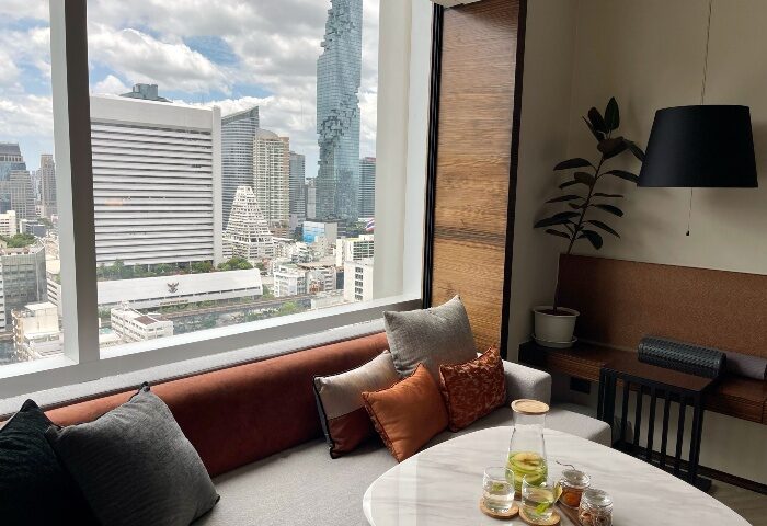 Le Méridien Bangkok hotel room with city view. Top gay hotels in Bangkok near gay saunas. Modern interior, comfortable seating.