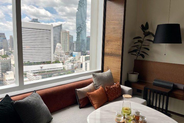 Le Méridien Bangkok hotel room with city view. Top gay hotels in Bangkok near gay saunas. Modern interior, comfortable seating.