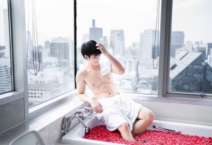Gay man in tub with rose petals, Bangkok view. Sathorn Vista, Marriott Executive Apartments: top gay hotels with best bathtub view.