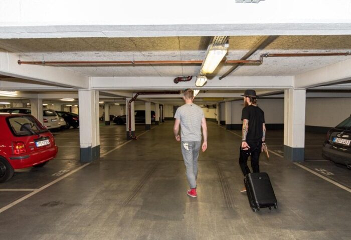 Gay couple with luggage at Ku'Damm 101 Hotel's free car park in Berlin. Top gay hotels in Berlin. Car park at Ku'Damm 101 Hotel.