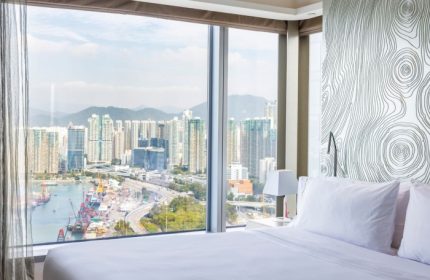 W Hong Kong hotel room view of Victoria Harbour. A top gay hotel with city views, skyscrapers, and a modern design.