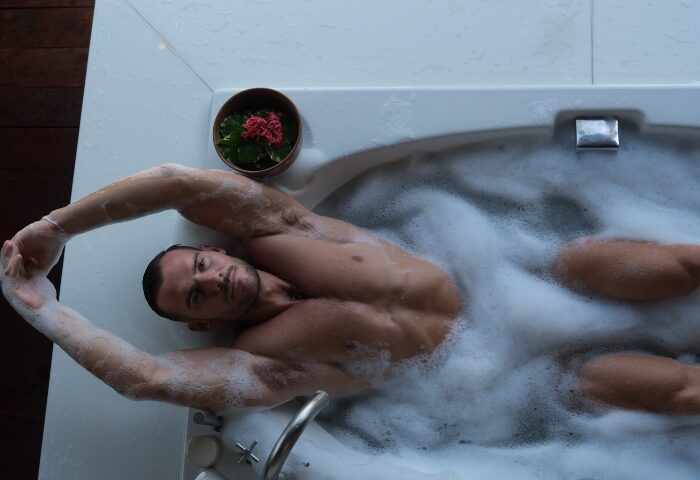 Garrya Tongsai Bay Samui: Man relaxes in a bubble bath. Top gay hotels Koh Samui offer private beach access and luxury amenities.