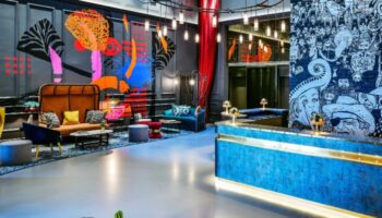 Andaz London Liverpool Street hotel lobby. Stylish design, colorful murals, and modern furniture. A top gay hotel in Shoreditch, London.