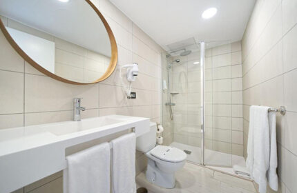 Atlantic Sun Beach gay men only hotel bathroom. Sink, mirror, shower, and toilet in Playa del Ingles adults-only hotel near gay nightlife.
