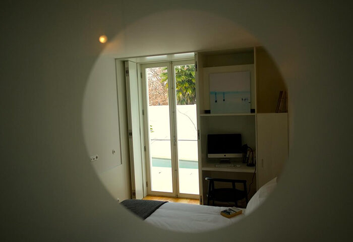 Bedroom view at The Late Birds Lisbon, a gay urban resort. Men-only hotel near gay bars. Modern design with a desk and outdoor view.