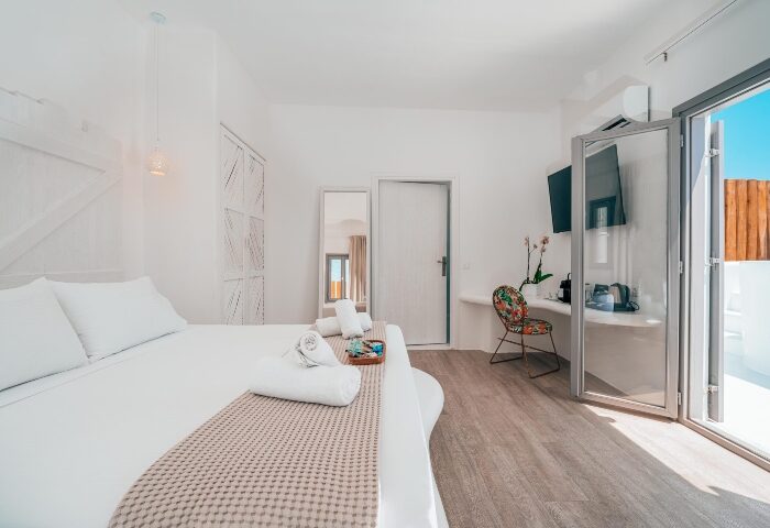 Akkadian Gay Hotel Mykonos room. Interior of top gay-only hotel in Mykonos. Clean, white decor with a bed and balcony.