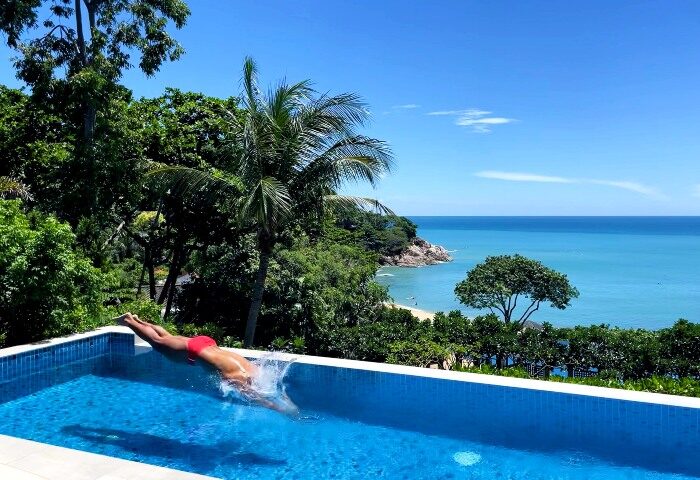 Man dives into pool at Garrya Tongsai Bay Samui, a top gay pool villa with private beach in Koh Samui. Tropical paradise, blue ocean view.