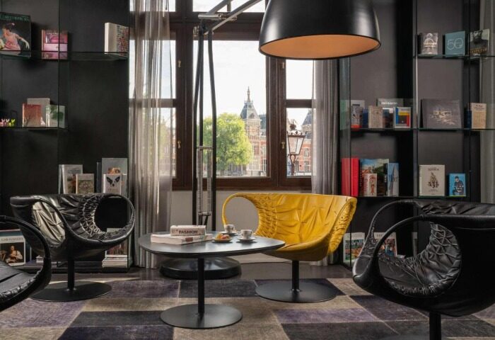 Trendy design at art'otel Amsterdam, a top gay hotel. Stylish seating area with yellow chair, perfect for gay travelers' Amsterdam stay.