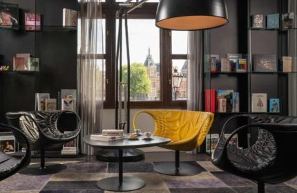 Trendy design at art'otel Amsterdam, a top gay hotel. Stylish seating area with yellow chair, perfect for gay travelers' Amsterdam stay.