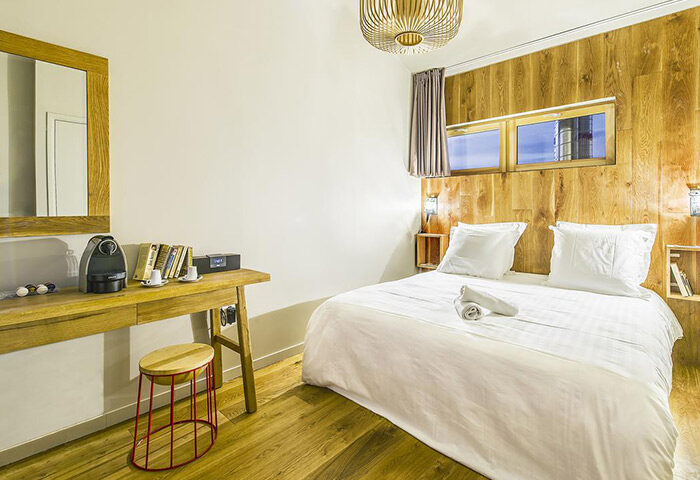 Les Piaules Hostel private double room. Modern design, wood paneling, desk with coffee maker. Top gay party hostel for gay travelers.