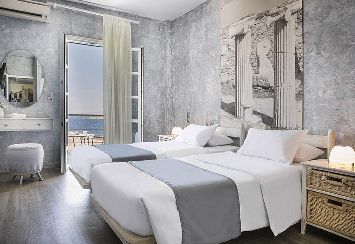 Ilio Maris honeymoon hotel room in Mykonos Town gayborhood. Twin beds, balcony with sea view, Greek-inspired decor.