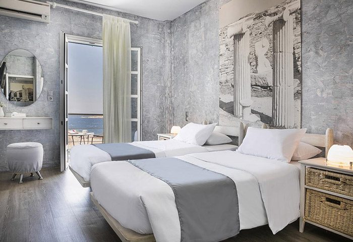 Ilio Maris honeymoon hotel room in Mykonos Town gayborhood. Twin beds, balcony with sea view, Greek-inspired decor.