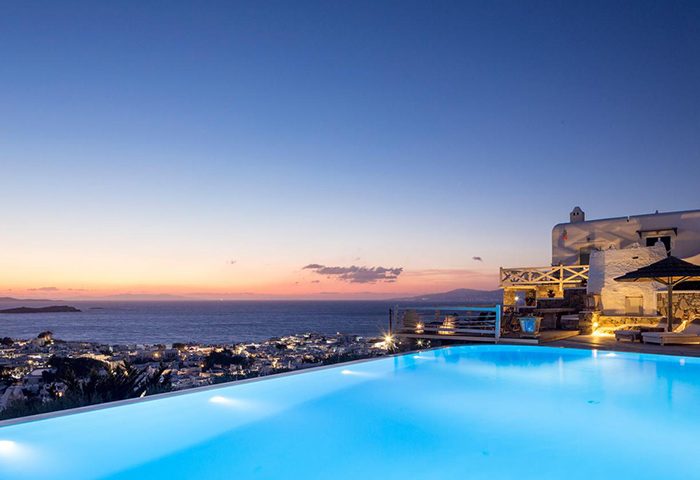 Vencia Boutique Hotel's rooftop infinity pool at dusk in Mykonos Town (Chora). Gay hotel with sea view. Top travel destination.