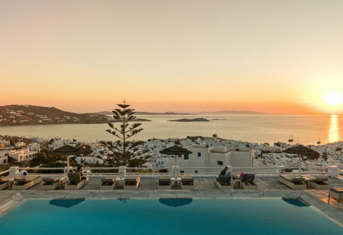 Hotel Alkyon, Mykonos rooftop pool view at sunset. Gay hotel with Instagram-perfect scenery and sea views. Top gay travel destination.