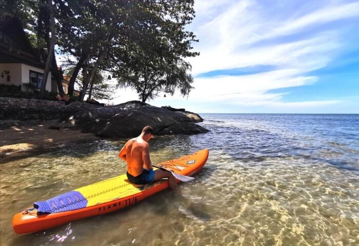 Rocky's Boutique Resort Samui: Man on paddleboard at top Koh Samui gay beach resort. Veranda Collection Samui offers gay travelers paradise.