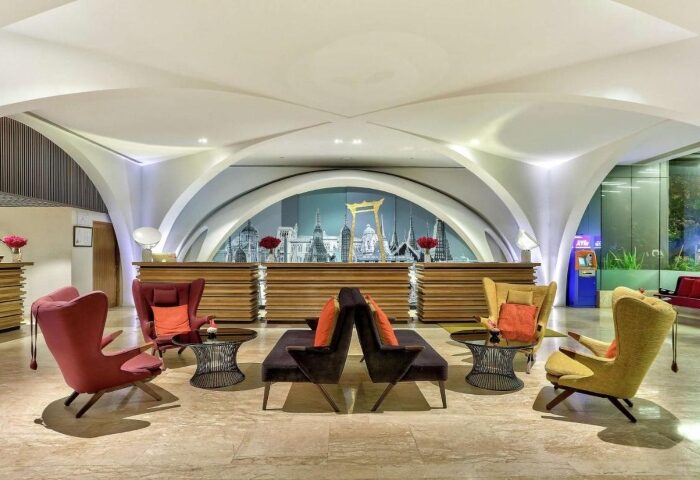 DoubleTree by Hilton Hotel Sukhumvit Bangkok lobby. Top LGBT hotel with modern design, seating area, and Bangkok skyline backdrop.