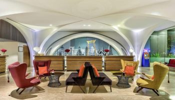 DoubleTree by Hilton Hotel Sukhumvit Bangkok lobby. Top LGBT hotel with modern design, seating area, and Bangkok skyline backdrop.