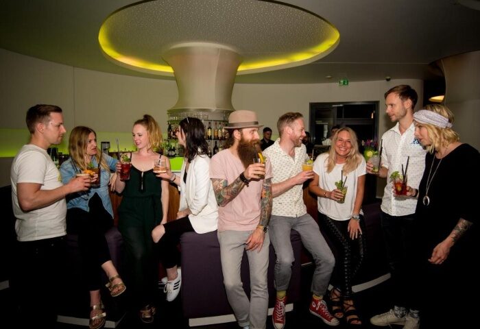 LGBT Hotel Ku'Damm 101, Berlin: Group of diverse, stylish people enjoying cocktails at the hotel bar near gay nightlife. Nightlife in Berlin.