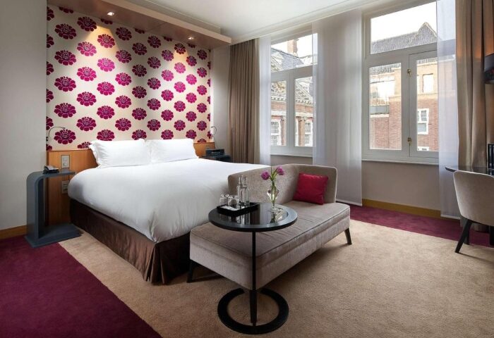 Sofitel Legend The Grand Amsterdam: Top luxury gay hotel room near gay bars. Elegant design, floral wallpaper, and comfortable seating.