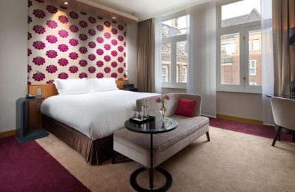 Sofitel Legend The Grand Amsterdam: Top luxury gay hotel room near gay bars. Elegant design, floral wallpaper, and comfortable seating.