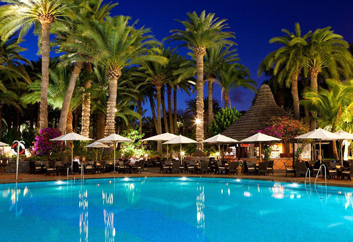 Seaside Palm Beach gay hotel pool at night. Luxury gay travel in Gran Canaria, Maspalomas. Top hotel for gay men's beach vacation.