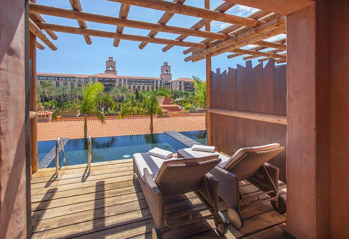 Lopesan Baobab Resort, Gran Canaria. Luxury gay hotel room view with pool, lounge chairs, and tropical scenery. Meloneras travel.