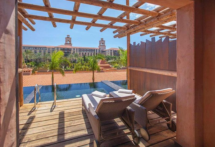 Lopesan Baobab Resort, Gran Canaria. Luxury gay hotel room view with pool, lounge chairs, and tropical scenery. Meloneras travel.