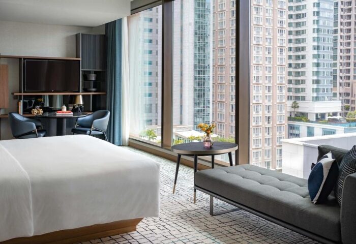 Kimpton Maa-Lai Bangkok, a top luxury gay hotel in Silom. Modern room with city view, bed, desk, & seating. Gay travel advice Bangkok.