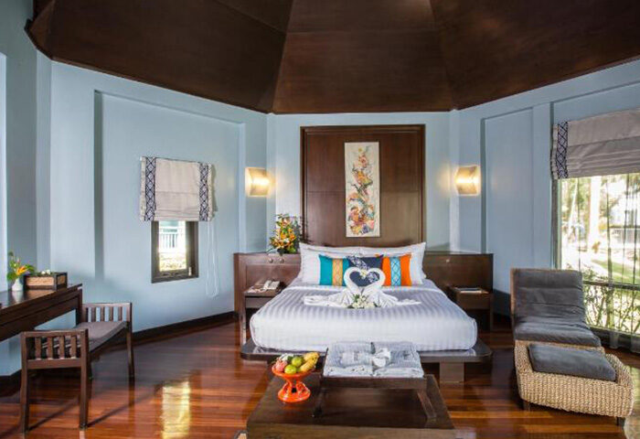 Peace Laguna Resort's top private pool villa. Gay hotel in Ao Nang, Krabi. Bedroom with king bed, swan towels, and wood floors.