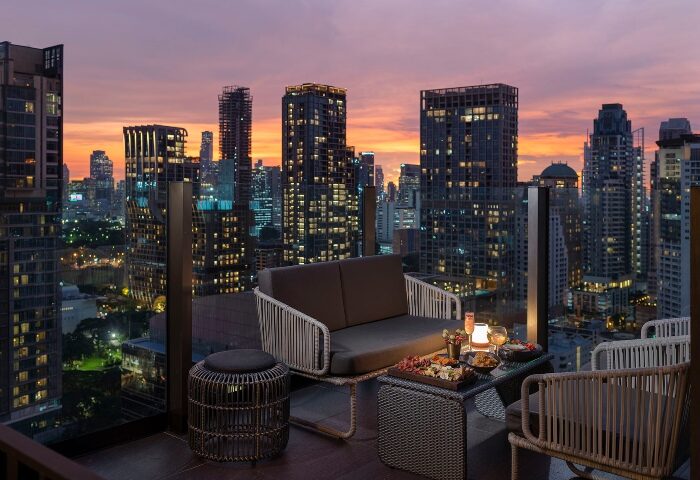 Hotel Indigo Bangkok Wireless Road rooftop bar at sunset. Gay-popular hotel with city views, cocktails, and snacks. Top Bangkok hotel.