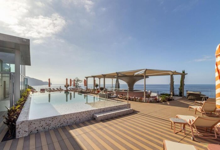 NEXT Hotel Madeira rooftop pool view. Gay beach hotel in Portugal with ocean views, lounge chairs, and bar area. Top gay hotel.