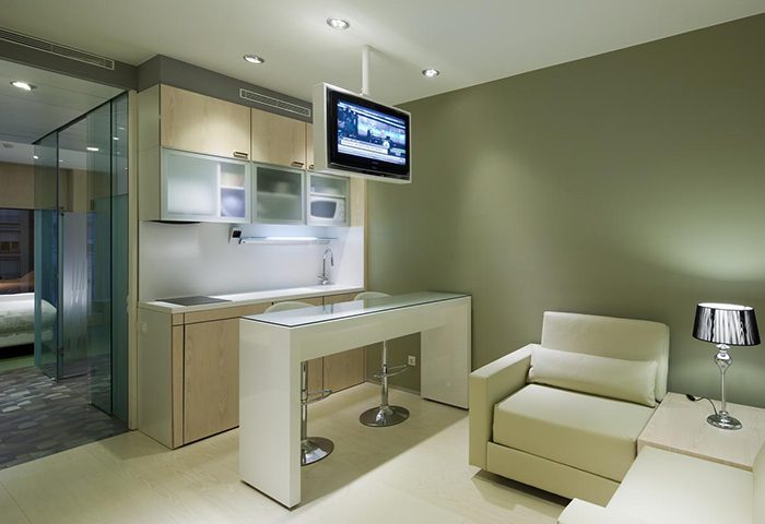 Ako Suites Hotel serviced apartment interior. Gay hotel in Barcelona's Eixample gayborhood. Modern design with kitchen, bar, and living area.