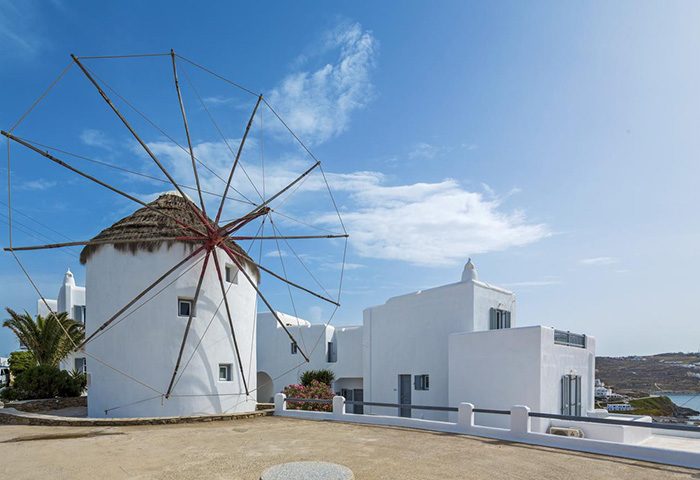 Absolute Mykonos Suites: Traditional windmills design near a gay hotel in Mykonos Town, Greece. Whitewashed buildings under a clear blue sky.